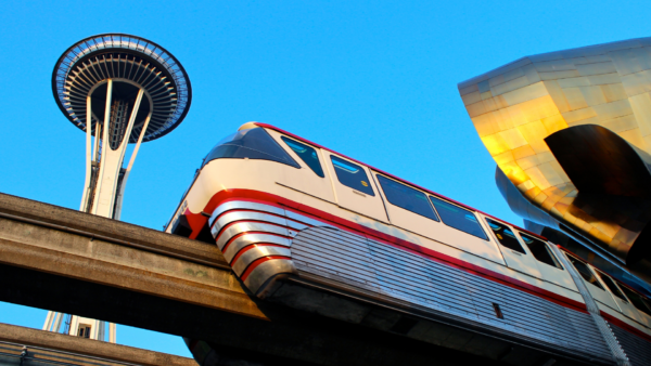 Seattle Center Monorail Red Train Passing by the Space Needle in Seattle, Washington