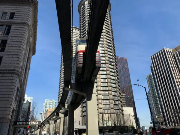 Street level viewpoint, looking up under the Seattle Monorail as it is travelling on the elevated track between the two stops in the route.
