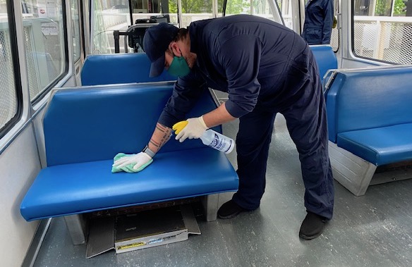 employee cleaning seats on train