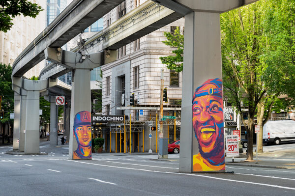 Oakland A's player and Seattle sports fan murals on monorail columns